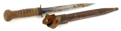 An early 20thC dagger, with unmarked blade, turned hardwood handle with indistinct monogram, the leather scabbard with indistinct scratch name, 38cm long.