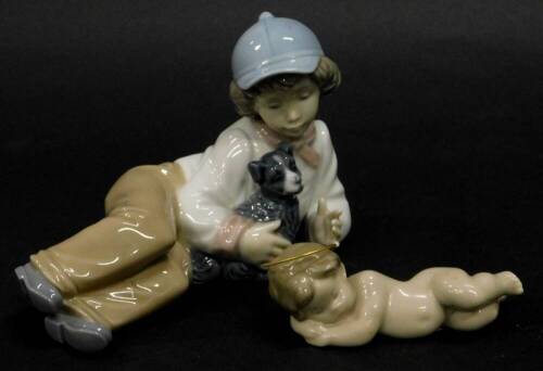 A Lladro porcelain reclining angel or cherub, and a Nao porcelain figure of a young boy reclining with a dog.
