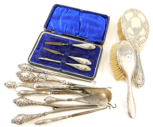 A collection of silver mounted dressing table items, to include two brushes, shoe horns, button hooks, glove stretchers, etc.
