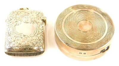 A George V circular silver pill box, with engraved lid, gilt interior, Birmingham 1927 and a silver Vesta case with engraved decoration and vacant cartouche, Chester 1903. (2)