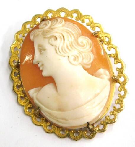 A 9ct gold framed shell cameo brooch, with oval cameo depicting maiden looking left, in scroll design engraved border, 4cm x 2.5cm, 6.3g all in.