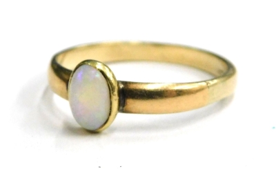 An opal set dress ring, with single oval opal in rub over setting, on a plain band, yellow metal, marked 9ct, ring size P, 2.1g all in.