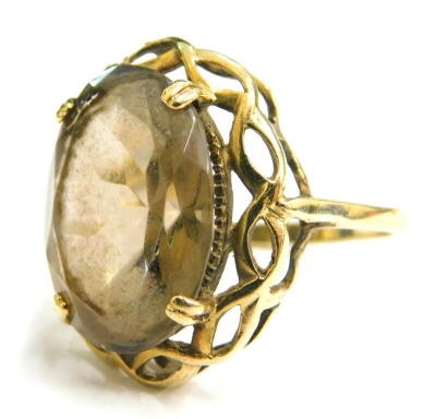 A 9ct gold chunky design smoky quartz dress ring, set with oval cut smoky quartz in four claw setting, with weave design border, ring size Q, 4.8g all in.