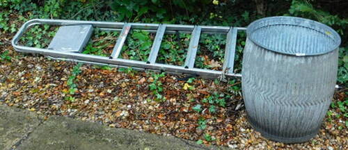 A galvanised metal dolly tub and a step ladder.