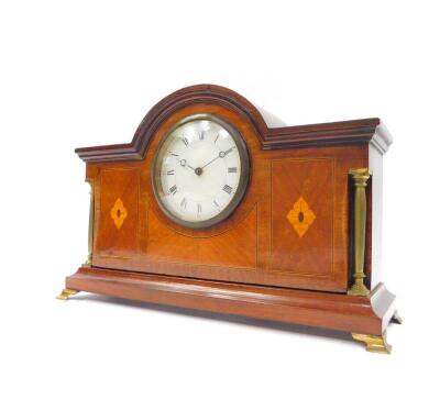 An Edwardian mahogany and inlaid mantel clock, circular dial bearing Roman numerals, clockwork movement with integral key, the case of architectural form, with brass columns, raised on brass bracket feet, 20cm high, 31cm wide, 9.5cm deep. - 2