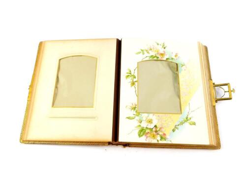 A Victorian cloth bound photograph album, embossed with flowers, with brass clasp, opening to reveal floral illustrated pages, 21.5cm wide, 28cm deep.