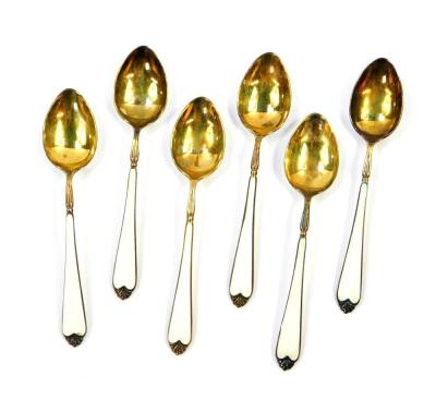 A set of six silver gilt and enamel coffee spoons, painted with flowers against a white guilloche and enamel ground, cased, Elkington & Company, Birmingham 1962, 2.23oz. - 2