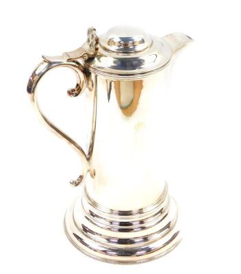 A 17thC style silver plated quart flagon, with a hinged lid and S scroll handle raised on a stepped circular base, 27cm high. - 2