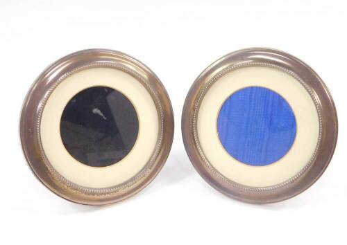 A pair of silver circular strut photograph frames, with beaded inner rims, Birmingham 1997 and 1998, 14cm diameter.