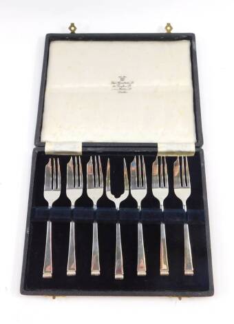 A George VI silver cake set, comprising six cake forks and a serving fork, cased, Sheffield 1946, 4.22oz.