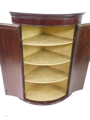 A George III flame mahogany bow front hanging corner cupboard, with satin lined interior shelves, 114cm high. - 2