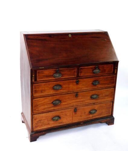 A George III mahogany bureau, with fall flap resting on lopers enclosing fitted interior, over two short and three long graduated drawers, with line inlay and oval back plate replacement handles, on bracket feet, 109cm wide.