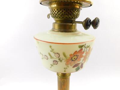 A Duplex brass oil lamp, with a floral painted opaline glass reservoir, glass chimney, and clear to yellow etched glass shade, 67cm high.