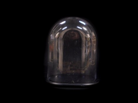 A modern moulded glass clock dome, raised on an ebonised wooden base, 32cm high, 27cm wide.