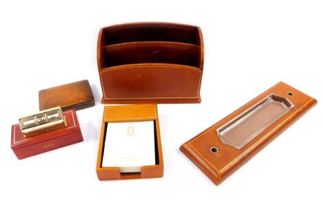 An Asprey of London tan leather three piece desk set, gilt tooled, comprising two tier stationery rack, 26.5cm wide., pen tray and holder, 38cm wide., and a stationery box holder, together with a Leon Jessel red leather box, surmounted with a perpetual de