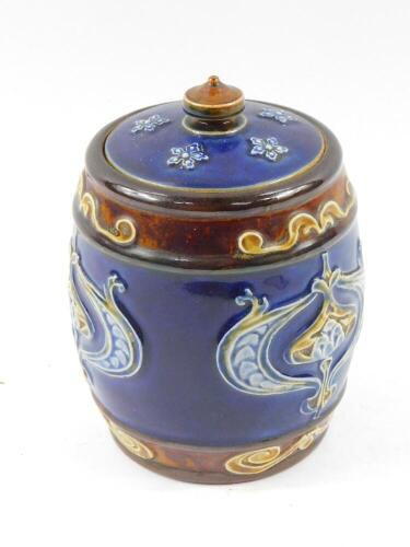 A Royal Doulton stoneware tobacco jar, decorated with Art Nouveau floral motifs against a blue ground, incised and impressed marks, 12.5cm high.