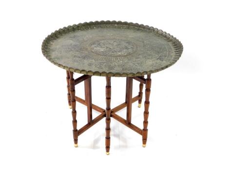 An Indian silvered metal tray top table, with turned folding base, 76cm diameter.