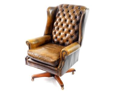 A Georgian style studded and button back leather swivel desk chair.