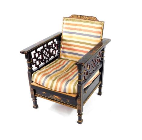 An early 20thC Japanned black lacquer and chinoiserie decorated reclining armchair, with fret work sides and carved cresting rail, 60cm over arms.