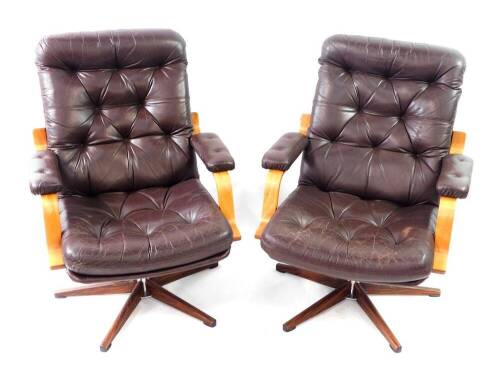 A pair of modern cantilever swivel office chairs, with brown leather effect upholstery and faux rosewood metal swivel base, labelled Montering; Denna Sida UPP.