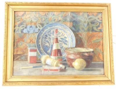 English School (British, 20thC). Still life of bottles, fruit, etc., against a background of patterned wallpaper, watercolour, 44cm high, 62cm wide.