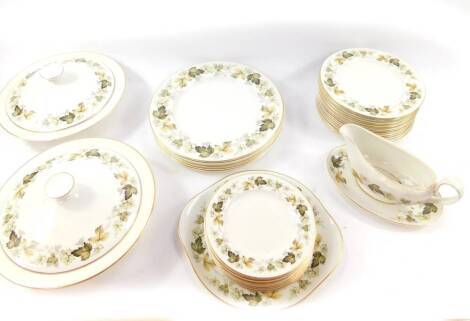 A Royal Doulton porcelain part dinner service decorated in the Larchmont pattern, comprising a pair of vegetable tureens and covers, sauce boat on stand, six dinner, thirteen dessert and twelve side plates, together with a bread plate.