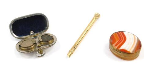 A Victorian propelling pen and pencil, yellow metal with a bloodstone set terminal, together with a silver plated sovereign and half sovereign case, and an oval brass box set to the lid and base with a red agate. (3)