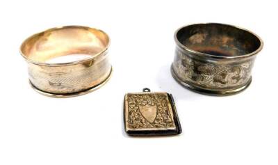 A George V silver envelope stamp case, with engraved foliate decoration, shield reserve, Chester 1913, together with two silver napkin rings, 0.88oz.