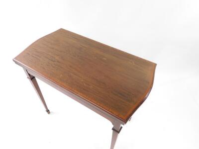 An Edwardian Sheraton Revival card table, with shaped rectangular fold over top with cross banding, on square taper legs with spade feet, 85cm wide. - 2