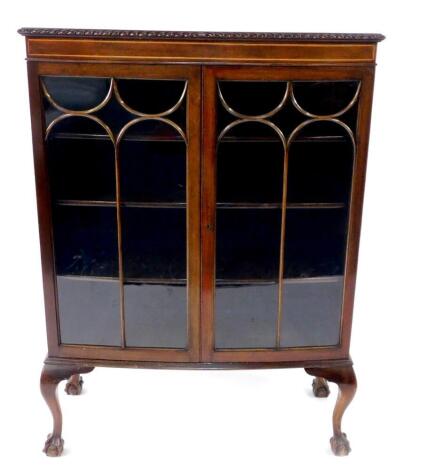 An early 20thC mahogany bow front display cabinet, with gadrooned top, astragal glazed doors, standing on cabriole legs with ball and claw feet, 92cm wide.