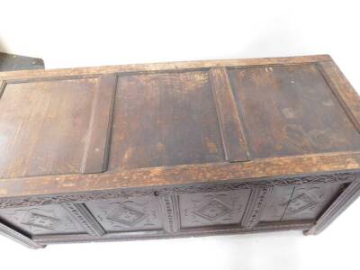 A 17thC oak coffer, with three panel top, Arabesque carved frieze, four lozenge carved panels to the front, raised on stiles, 68cm high, 147cm wide, 59cm deep. - 4