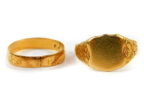 A lady's 18ct gold shield shaped signet ring, with embossed floral decoration, size M, together with an 18ct gold wedding band, size K, 4.6g. (2)