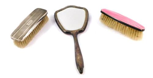 A silver and pink guilloche enamel dressing table mirror and clothes brush, Elkington & Company, Birmingham 1964, together with a further brush, presentation engraved, Adie Bros, Birmingham 1962.