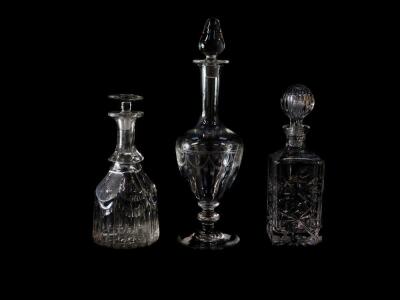 A Continental glass decanter and stopper, engraved with festoons, bears label, 40cm high, together with a Victorian cut glass decanter with later stopper, 27cm high., and a modern cut glass decanter and stopper, 28cm high. (3)