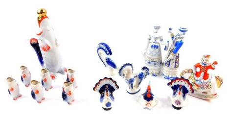 A Russian porcelain liqueur set, of standing fish form, comprising a decanter and stopper and six tots, together with three figures of turkeys, a chicken, horse, Holohaza figure group, and a pottery figure of a man seated on a rocking horse. (a quantity)