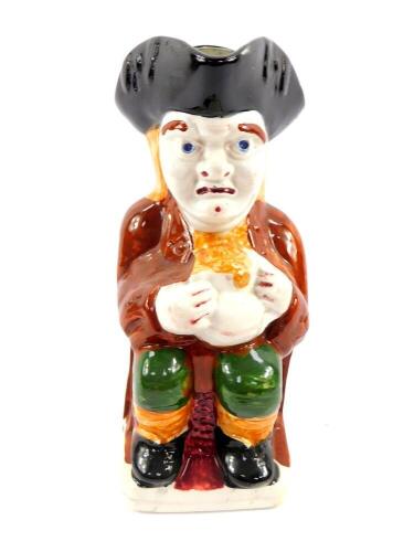 A Staffordshire mid 19thC grotesque Toby jug, modelled traditionally seated with a jug of frothing ale, 25cm high.