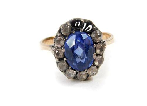 A Ceylon sapphire and diamond ring, the oval cut sapphire in a surround of diamonds, set in yellow metal, size M, sapphire approx 1 1/2ct, diamonds approx 2/3rd cts, size M, 3.0g, two diamonds lacking.