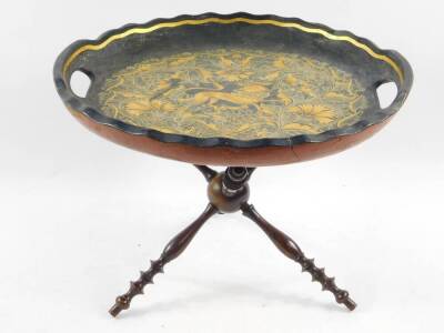 A Continental 19thC black lacquer circular twin handled tray, gilt decorated with an exotic bird, wild animal, flowers, and foliate scrolls, raised on a turned wooden cat stand, 27cm high, 39cm diameter.