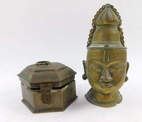 An Indian brass pandan box, 12cm diameter, together with a brass wall mounted bust of a Hindu deity, 19.5cm high. (2)