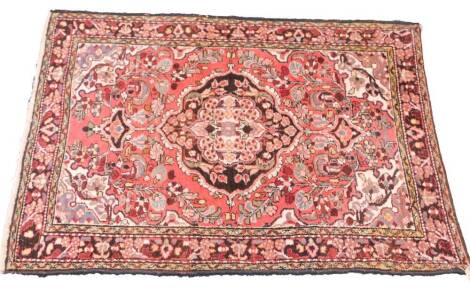 A Caucasian red ground rug, decorated with a central medallion, floral and foliate motifs, 159cm x 121cm.