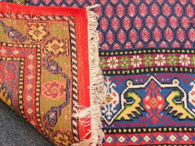 A Caucasian red ground rug, the central field decorated with floral motifs, within a border of botehs and repeating flowers and leaves, 275cm x 172cm. - 3