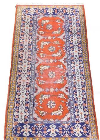 A Caucasian light brown ground rug, decorated with four central fields, with floral and floriate motifs, within floral borers, 169cm x 94cm.