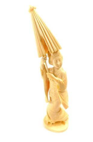 A Japanese ivory okimono figure of a geisha holding a parasol aloft, signed to base Taisho period, 21cm high.