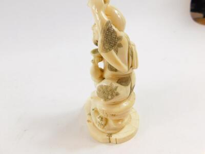 A Japanese marine ivory okimono of Ebisu, holding his carp above his head in one hand, his double gourd sake bottle and bowl in the other hand, signed Unichi (?) to base Meiji period, 13.5cm High. - 3