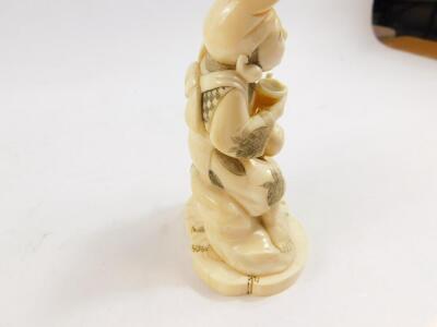 A Japanese marine ivory okimono of Ebisu, holding his carp above his head in one hand, his double gourd sake bottle and bowl in the other hand, signed Unichi (?) to base Meiji period, 13.5cm High. - 5