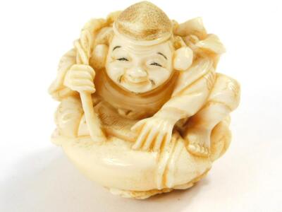 A Japanese ivory netsuke of Ebisu, seated on his giant carp, Meiji period, 6cm High.