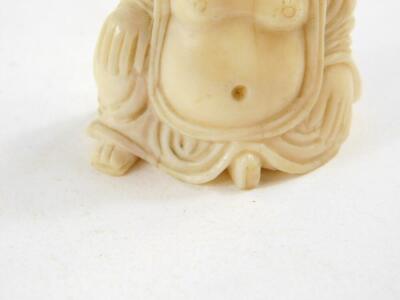 An Oriental ivory figure of a seated Buddha, (being part of another composition with insert to side of head), 19thC., 5cm high. - 2