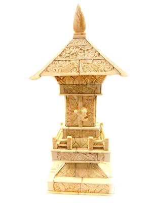 A late 19thC Japanese sectional carved bone model of a Buddhist shrine, the doors opening to reveal the seated figure of Buddha, 28cm high.