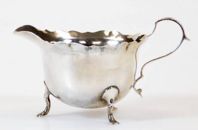 A George V silver cream jug, with flared rim, acanthus capped ear handle and triple hoof feet, London 1912, 8cm high, 2oz.