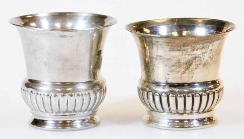 A matched pair of early 20thC silver vases, each of campana form, partially gadrooned on circular feet, various dates, 8cm high, 2.5oz. (2)